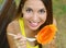 Girl eating healthy papaya in the park looking at camera. Woman eating tropical fresh fruit outdoor.