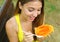 Girl eating healthy papaya in the park. Woman eating tropical fresh fruit outdoor