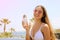 Girl eating ice cream on Tenerife beach with palm trees on the background