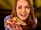 Girl eating piece of pizza
