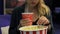 Girl eating popcorn and drinking a drink