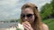 Girl eating a sandwich on summer day. Hungry young woman biting piece sandwich