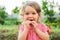 Girl Eating Sausage At Family Barbeque. 2 years old girl eats sausage