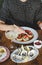 Girl eating sushi with chopsticks and fresh oysters on table