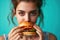 Girl Eats Burger On Turquoise Background
