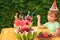 Girl eats fruit in garden, happy birthday party