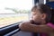 A girl of eight years looks out the window in an electric train