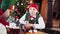 Girl in elf costume sitting at festive table.