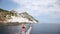 Girl enjoy on nose of the boat and watching the trip over the sea near islands its like Titanik scene without boy