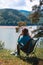 Girl enjoy the view on the mountain overlooking the lake. They sit on folding portable camping chairs. Concept of equipment for