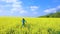 Girl enjoying at the blooming rapeseed field at bright sunny day