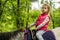 Girl enjoying horseback riding in the woods, young pretty girl with blond curly hair on a horse with backlit leaves