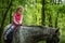 Girl enjoying horseback riding in the woods, young pretty girl with blond curly hair on a horse with backlit leaves