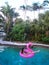A girl enjoying on the pool in flamingo float