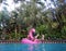 A girl enjoying on the pool in flamingo float