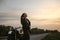 Girl enjoying sunset while standing by the motorcycle