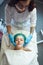 Girl enjoys cosmetic procedures in a cosmetology clinic. Beautician applies peeling on the face of a young girl.