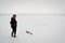 Girl enjoys snow. Young woman in black during a snowfall.