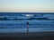 Girl entering the ocean at sunset.