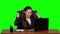 Girl enthusiastically works behind a laptop, smiles and enjoys the result. Green screen. Slow motion