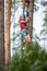 Girl in equipment overcomes an obstacle in a rope park