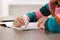 Girl erasing mistake in her homework at wooden table indoors, closeup