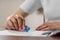 Girl erasing mistake in her notebook at wooden desk, closeup