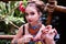 Girl in ethnic clothes in tropical garden with snake