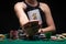 Girl in evening dress poker player shows a joker card on the background of chips, money. The concept of a casino, gaming hall,