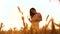 Girl evening is standing in in the wheat field nature slow motion video. beautiful girl in white dress running hands to