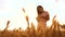 Girl evening is standing in in the wheat field nature slow motion video. beautiful girl in white dress running hands to
