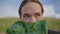 Girl examining cabbage closely on field. Portrait woman holding lettuce at face