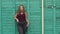 A girl with excess weight next to a green wall.