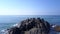 Girl exercises on large rocky cliff at endless ocean