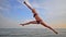 Girl exercising a gymnastic on the sea coast.