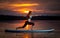 Girl exercising yoga on paddleboard in the sunset on scenic lake Velke Darko