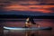 Girl exercising yoga on paddleboard in the sunset on scenic lake Velke Darko