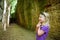 Girl exploring Etruscan Le Vie Cave Via Cava, the path connecting ancient necropolis and settlements in the area between Sovana