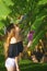 Girl exploring the nature - examining banana tree, flower and fruits growing on a green tree. A smiling young woman with green