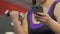 Girl with extra weight lifting dumbbell, scrolling cellphone screen, distraction