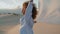Girl fabric blowing wind at summer desert. Woman posing with white cloth at sand
