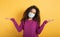 Girl with face mask has a lot of question about covid 19. Yellow background