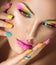 Girl face with vivid makeup and colorful nail polish