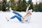 Girl falling down while ice skating at winter rink