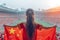 Girl fan stands in stadium, holding China flag, embodying national pride and sports enthusiasm