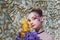 girl with fancy creative make-up holding iris flowers bouquet