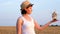 A girl farmer holds a windmill toy in her hand against the background of a wheat field