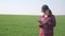 Girl farmer red neck with a digital tablet lifestyle walks on a green field. Eco farming agriculture concept. Woman