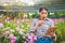 A girl farming a flower farm holding a tablet