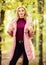 Girl fashionable blonde walk in park. Best puffer coats to buy. How to rock puffer jacket like star. Fall fashion